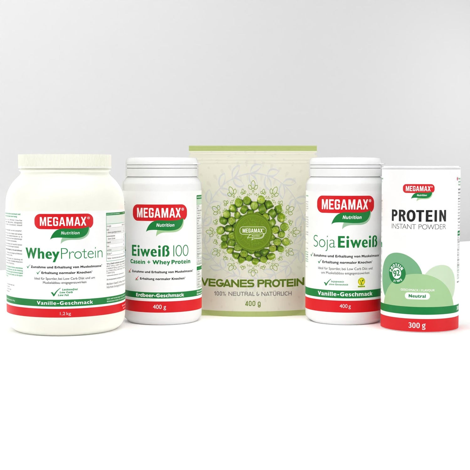 Das Bild zeigt fünf MEGAMAX-Proteinprodukte: Whey Protein (Vanille, 1,2 kg), Eiweiß 100 (Erdbeer, 400 g), Veganes Protein (neutral, 400 g), Soja Eiweiß (Vanille, 400 g) und Protein Instant Powder (neutral, 300 g) vor einem hellgrauen Hintergrund.